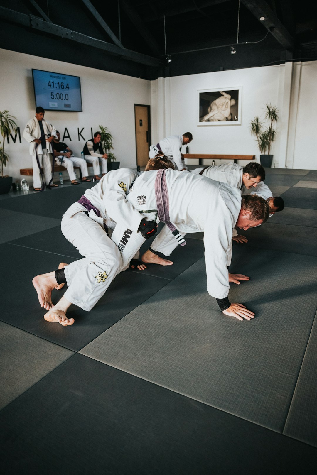 FAQ by MMA Ninja man in white karate gi kneeling on black carpet